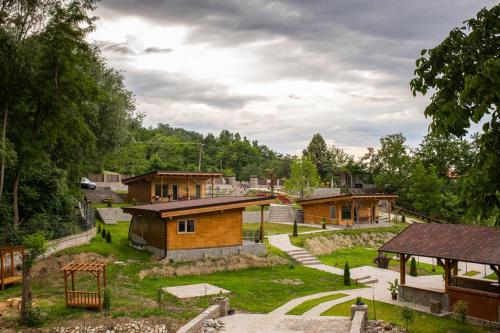 a group of buildings in a park with trees at Mon Resort by Ana1St in Scărişoara