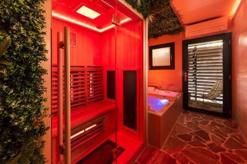 a red bathroom with a tub and a sink at Minamina, chambre avec jacuzzi privatif in Roquefort-la-Bédoule
