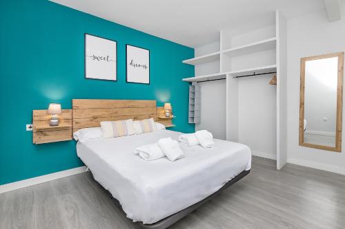1 dormitorio con 1 cama grande y pared azul en BHost - San Pedro, en Córdoba