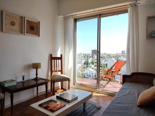 un soggiorno con divano e una grande finestra di FLORESTA, cómodo departamento en CABA a Buenos Aires