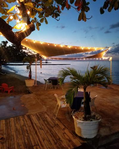 a patio with a table and chairs and lights at Sand and Tan Beach Hotel in Ocho Rios