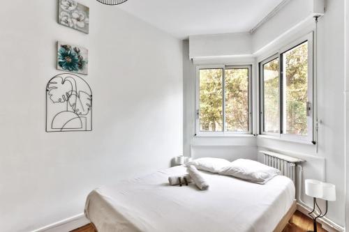 une chambre blanche avec un lit et une fenêtre dans l'établissement Appartement Chérioux - Welkeys, à Paris