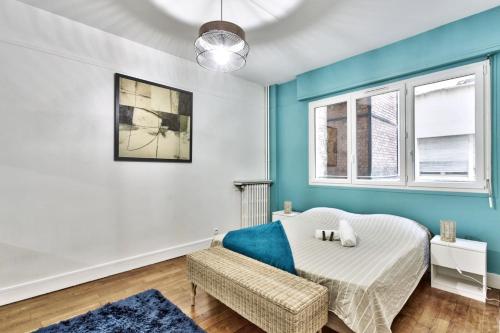 une chambre avec un lit et un mur bleu dans l'établissement Appartement Chérioux - Welkeys, à Paris