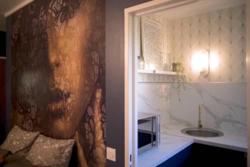 uma casa de banho com um lavatório e um espelho em Le Boudoir, Centre ville, Parking couvert inclus em Mulhouse