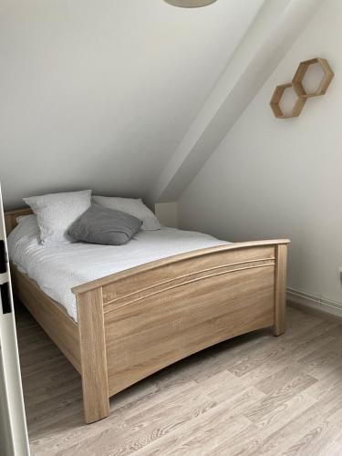 a bed with a wooden frame in a room at CAP SUR SAINT-VAL in Saint-Valery-sur-Somme