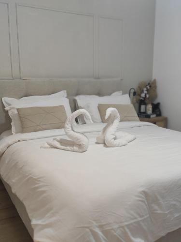 two swans are sitting on a white bed at Emanuel Suite in Eilat