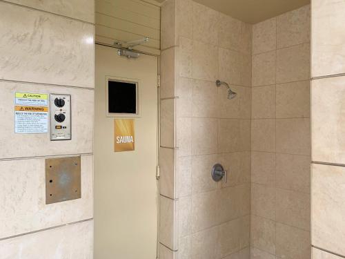 a bathroom with a shower with a glass door at Vacation Rental Studios at Royal Garden Waikiki in Honolulu