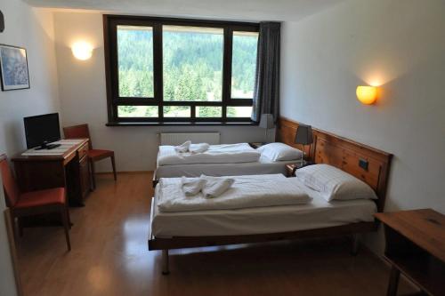 a room with three beds and a desk and a window at Gästehaus Schwabach in Schwabach