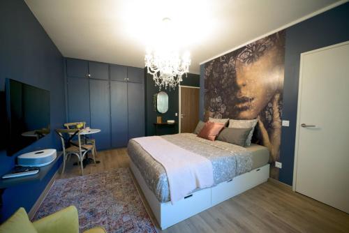 a bedroom with a king sized bed and a chandelier at Le Boudoir, Centre ville, Parking couvert inclus in Mulhouse