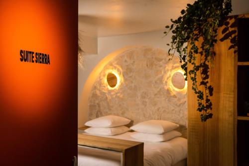 a bedroom with a bed with a stone wall at Minamina, chambre avec jacuzzi privatif in Roquefort-la-Bédoule