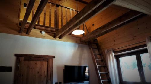 a room with a ladder and a tv and a window at Chata Líška JASNA in Liptovský Mikuláš