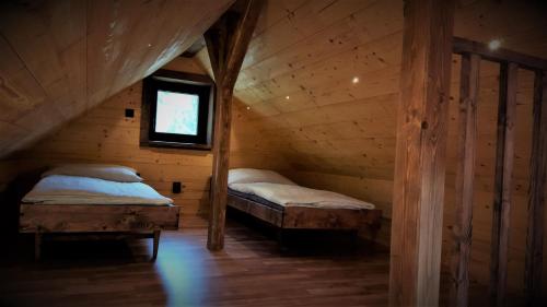 a bedroom with two beds in a wooden cabin at Chata Líška JASNA in Liptovský Mikuláš