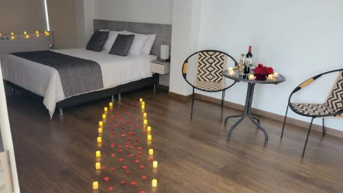 a bedroom with a bed and a table and chairs at Hotel Piedras De Maní in Manizales