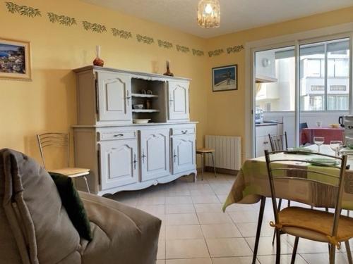 una sala de estar con un armario blanco y una mesa. en Appartement Balaruc-les-Bains, 2 pièces, 4 personnes - FR-1-503-84, en Balaruc-les-Bains