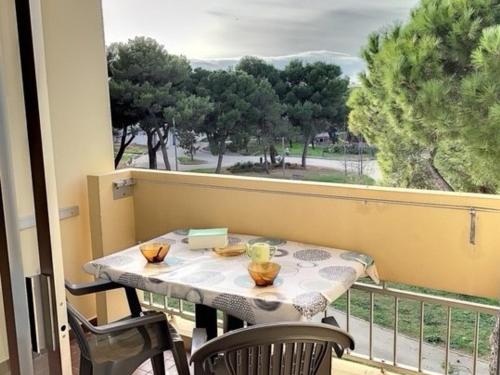 une table et des chaises sur un balcon avec une fenêtre dans l'établissement Studio Cosy 2* - Proche Thermes et Étang, Parking Inclus - FR-1-503-103, à Balaruc-les-Bains