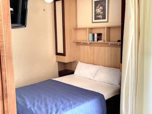 une petite chambre avec un lit dans une petite pièce dans l'établissement Appartement ⭐⭐ proche Thermes, Étang, commerces avec balcon, ascenseur, WIFI, parking - Animaux ok - FR-1-503-95, à Balaruc-les-Bains