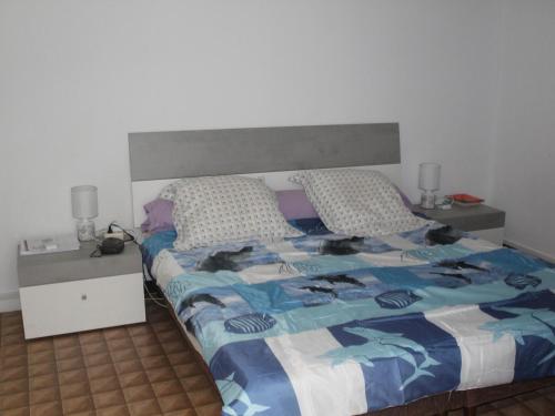 une chambre avec un lit et deux tables de nuit dans l'établissement T2 Confortable, Animaux OK, Wifi, Près des Thermes - FR-1-503-118, à Balaruc-les-Bains