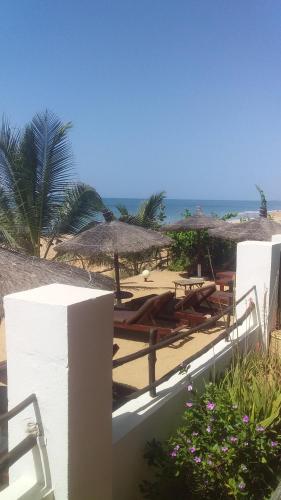 a beach with umbrellas and chairs and the ocean at Terra Lodge Sénégal in Mbour