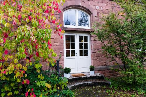 a brick house with a white door and flowers at Design Loft I 130 qm I Europapark 20min I 2 Etagen I 2 Bäder I Nespresso I Parkplatz in Lahr