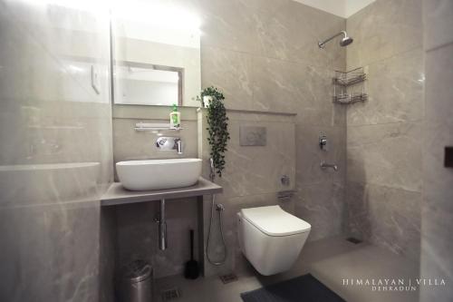 a bathroom with a toilet and a sink and a shower at Himalayan Villa in Dehradun