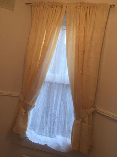 a window with a white curtain in a room at Devons Unique Short Stay in London
