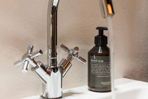 a bottle of liquid soap sitting on a bathroom sink at Design Loft I 130 qm I Europapark 20min I 2 Etagen I 2 Bäder I Nespresso I Parkplatz in Lahr