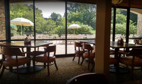 a restaurant with tables and chairs and a large window at Couples Condo Retreat Overlooking Golf Course in Branson West