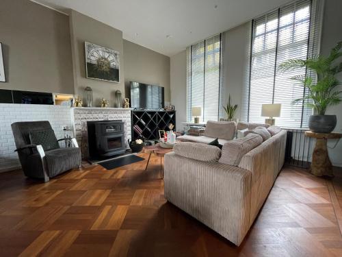 a living room with a couch and a fireplace at De Oude Pastorie Lisse in Lisse