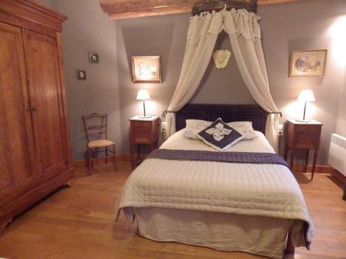 a bedroom with a bed with a canopy at Ferme Clatot in Les Trois Pierres