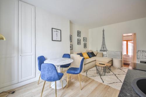 ein Wohnzimmer mit einem Tisch und blauen Stühlen in der Unterkunft 11#Appartement 4Pers#Sèvres-Lecourbe#Necker in Paris