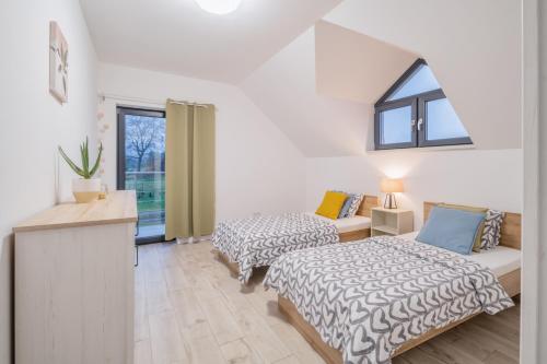 sypialnia z 2 łóżkami i oknem w obiekcie Domek na wsi w Polanicy Zdroju