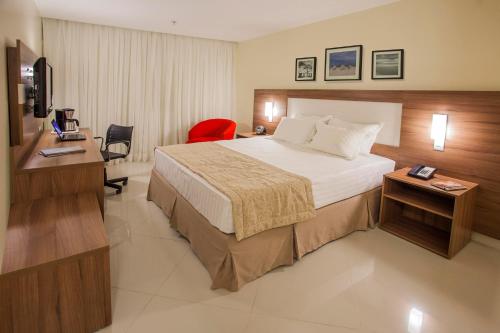 a hotel room with a large bed and a desk at Holiday Inn Express Belem Ananindeua by IHG in Belém