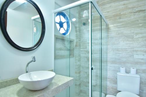 La salle de bains est pourvue d'un lavabo et d'une douche en verre. dans l'établissement Pousada Tanto Mar, à Arraial do Cabo