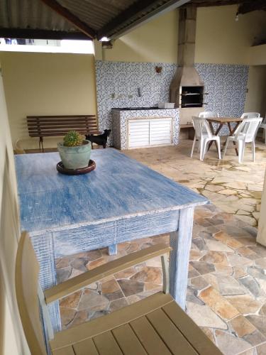 Una mesa azul en una habitación con suelo de piedra. en Ótima localização em Ubatuba, en Ubatuba