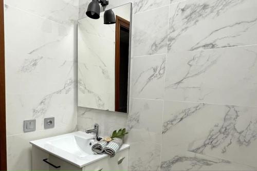 La salle de bains blanche est pourvue d'un lavabo et d'un miroir. dans l'établissement Piso reformado en el centro de Logroño, à Logroño