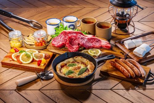 einen Tisch voller Lebensmittel mit Fleisch und anderen Lebensmitteln in der Unterkunft OKAYAMA GLAMPING SORANIA - Vacation STAY 73195v in Kurashiki