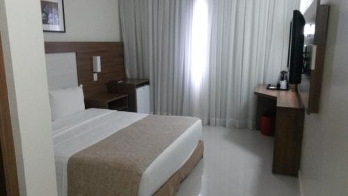 a hotel room with a bed and a television at Holiday Inn Express Belem Ananindeua by IHG in Belém