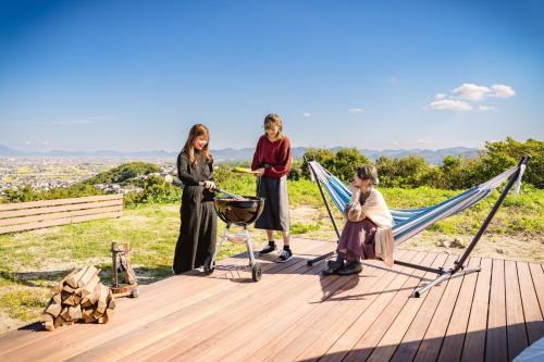 倉敷的住宿－OKAYAMA GLAMPING SORANIA - Vacation STAY 20221v，一群站在带吊床的甲板上的女人
