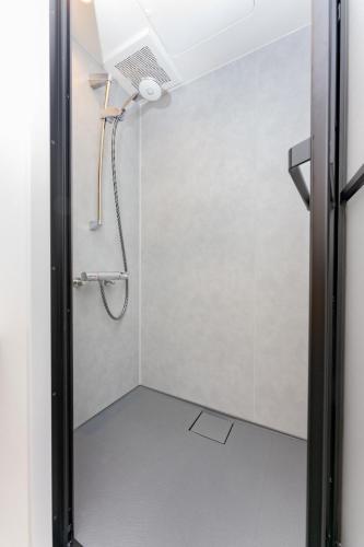 ein Bad mit einer Dusche mit einem Duschkopf in der Unterkunft OKAYAMA GLAMPING SORANIA - Vacation STAY 20221v in Kurashiki