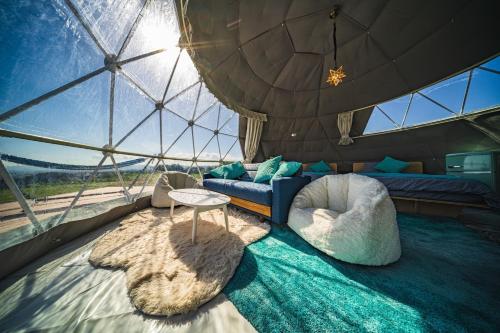 倉敷的住宿－OKAYAMA GLAMPING SORANIA - Vacation STAY 20221v，圆顶内的房间,配有沙发和桌子
