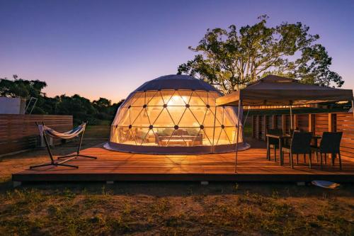 倉敷市にあるOKAYAMA GLAMPING SORANIA - Vacation STAY 20221vの大きなドームの建物で、デッキにテーブルと椅子が備わります。