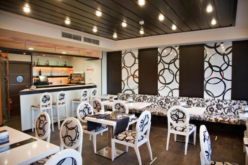 a restaurant with white chairs and tables and a counter at Hotel Boutique Estrella del Mar in Peñíscola