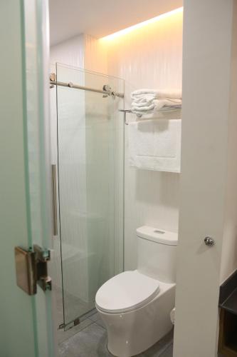 a bathroom with a toilet and a glass shower at The Lu'um House in Tuxtla Gutiérrez