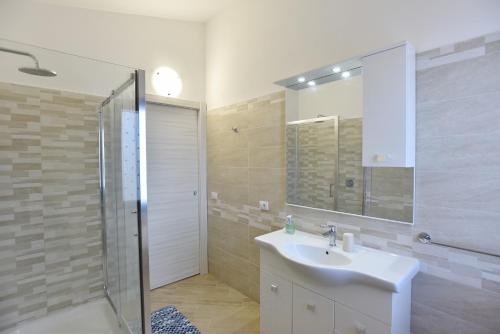 a bathroom with a white sink and a shower at Casa Terra Del Sole in Pula