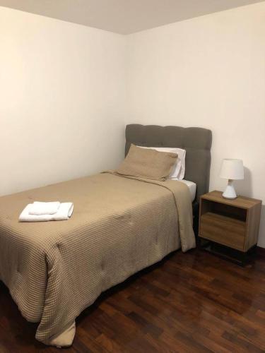 a bed with two towels on it in a bedroom at Vistamar Duplex in Lima