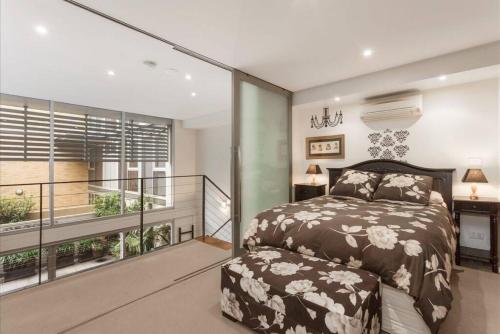 een slaapkamer met een bed en een balkon bij Spacious 4 brm Gem right in the heart of the city in Melbourne