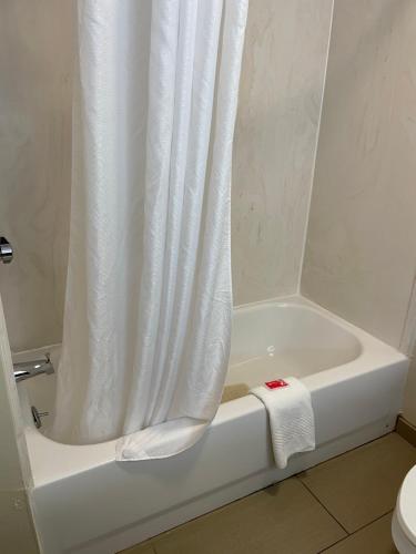 a bathroom with a bath tub with a shower curtain at Econo Lodge Newport West in Newport