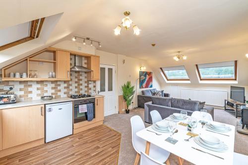 a kitchen and a living room with a table and chairs at Bridge End Mill by Guestz in Settle