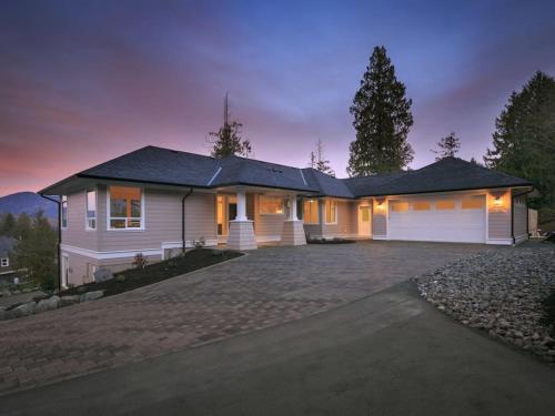 a large white house with a garage at night at Big 4 Bd, 4 Ba home, Steps to Ocean with EV Charger in Cowichan Bay