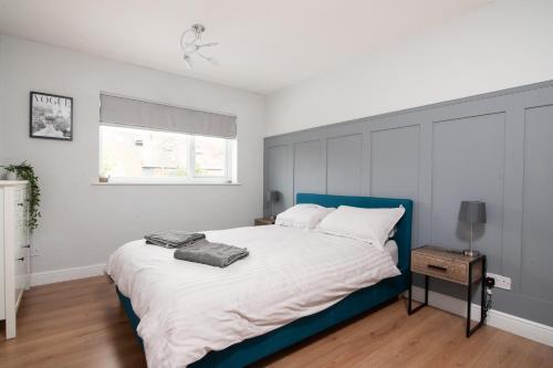 a bedroom with a large bed with a blue headboard at 'Modern Living in Old Town Stratford-upon-Avon' in Stratford-upon-Avon